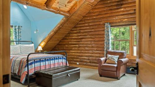 Bigwood Cabin Retreat Hot Tub Game Room Firepit Lounge Private Yard في Long Pond: غرفة نوم كابينة خشب بها سرير وكرسي