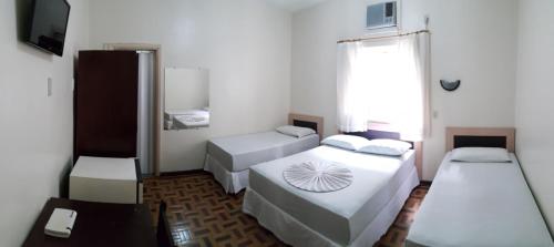 a small room with two beds and a tv at Hotel Figueira Palace in Dourados