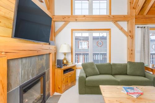 a living room with a couch and a flat screen tv at Alpine Timbers 2 Luxury Chalet with Hot Tub in Big White