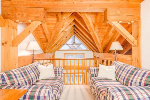 ビッグ・ホワイトにあるAlpine Timbers 2 Luxury Chalet with Hot Tubの木製の天井のリビングルーム(ソファ2台付)