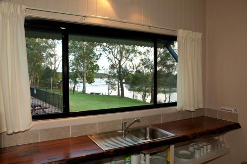 a kitchen with a sink and a window at Wooli River Lodges in Wooli
