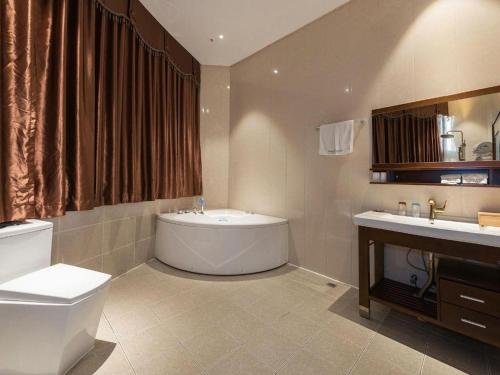 um banheiro com banheira, vaso sanitário e pia em James Joyce Coffetel· Tianjin Olympic Center Lingbin Road Metro Station em Tianjin