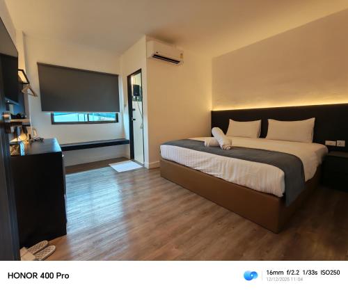 una camera da letto con un letto grande e una televisione di The loft hotel Betong a Betong