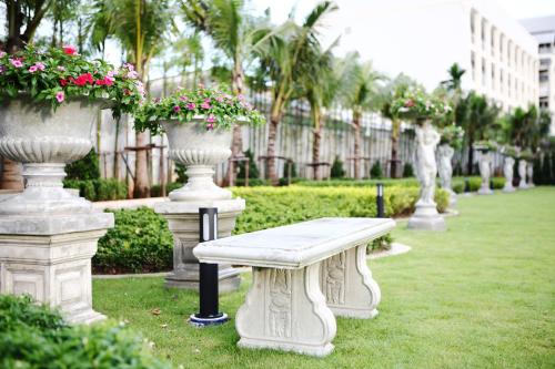 a bench in a park with vases and flowers at The Malika Hotel - SHA Extra Plus in Phuket Town