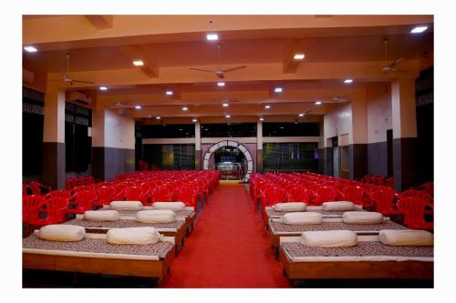 una habitación llena de sillas rojas y colchones en Kamala Shanti Palace, en Solapur