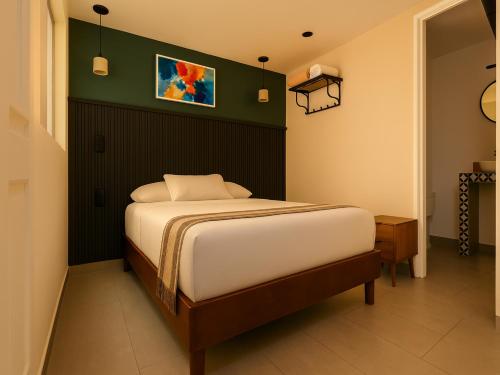 a bedroom with a bed and a green wall at Collection O Hotel Concreta 199 Mexico City in Mexico City