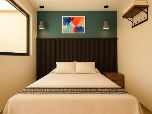 a bedroom with a bed and a green wall at Collection O Hotel Concreta 199 Mexico City in Mexico City