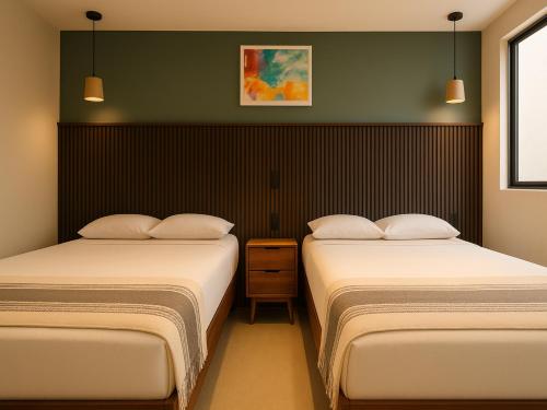 two beds in a small room with at Collection O Hotel Concreta 199 Mexico City in Mexico City