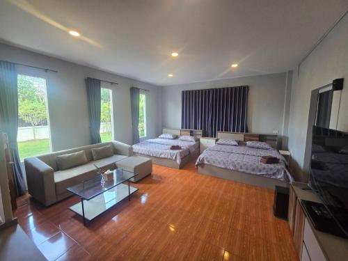 a living room with two beds and a couch at Chaba4 in Ban Nong Bua Noi
