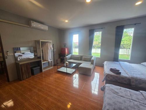 Chaba4 في Ban Nong Bua Noi: غرفة معيشة بها أريكة وطاولة