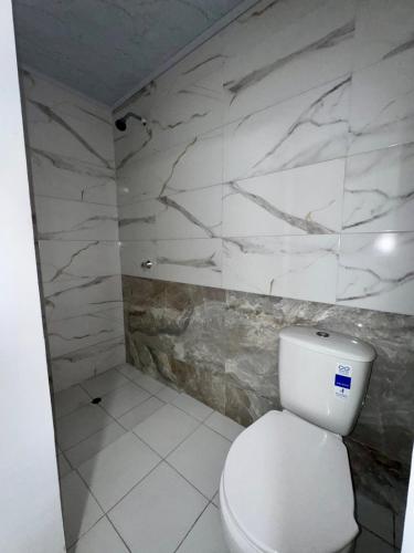 Orilla beach house في Playa Punta Arena: حمام به مرحاض أبيض وجدار من الرخام