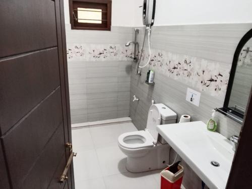a bathroom with a toilet and a sink at Bosadi Apartment katunayaka in Katunayaka