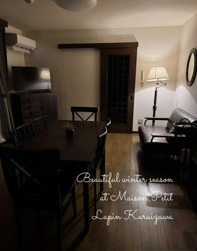 a living room with a table and a couch at Maison Petit Lapin メゾンプチラパン in Karuizawa