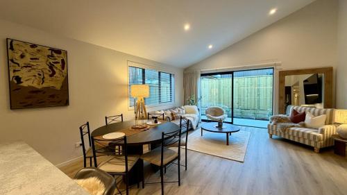 a living room with a table and a dining room at Luxurious Stay with Mountain Views in Queenstown