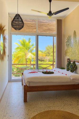 a bedroom with a large bed and a large window at The One Resort Zanzibar in Makunduchi