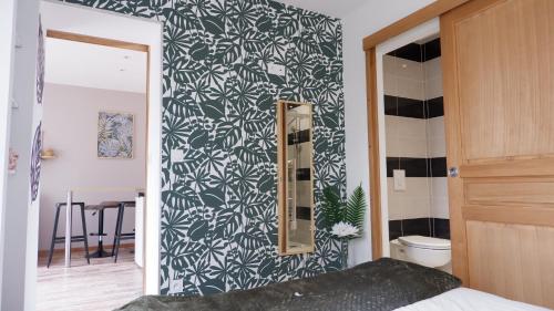 a bedroom with a black and white patterned wall at A l'étoile du soir in Nançay