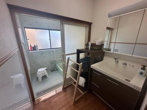 ein Badezimmer mit Dusche, Waschbecken und Toilette in der Unterkunft MIYABI stay house in Tamana