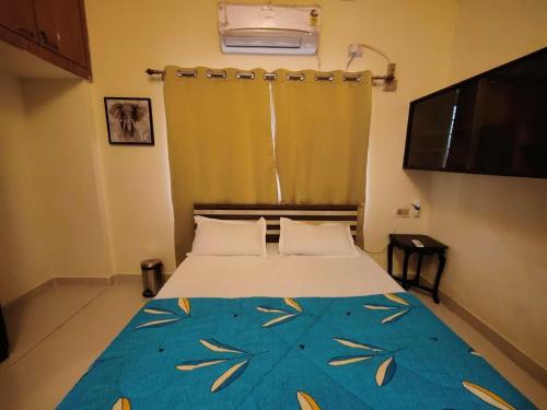 a bedroom with a bed with a blue blanket at Zivo Stays, Heritage Apartments, Rethibowli in Hyderabad