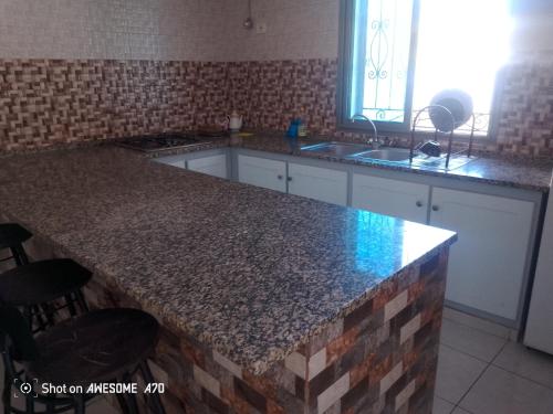 メズライアにあるappartement 1 Midoun centreの御影石のカウンタートップとシンク付きのキッチン