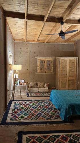 a bedroom with a bed and a couch in a room at Paloma Wooden House !!! in Siwa