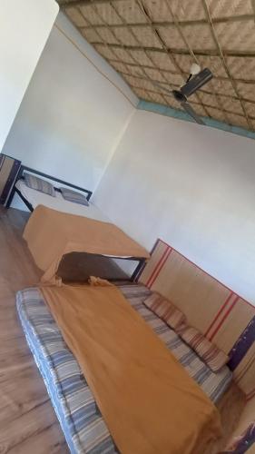 2 camas en una habitación con techo en Hampi nest gust house, en Hampi
