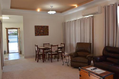 a living room with a table and chairs and a couch at Norseman AirbnbAngels Place in Norseman