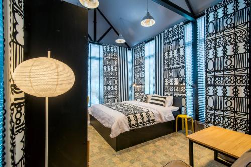a bedroom with a bed and a table and a lamp at Villa Na Pran, Pool Villa in Pran Buri