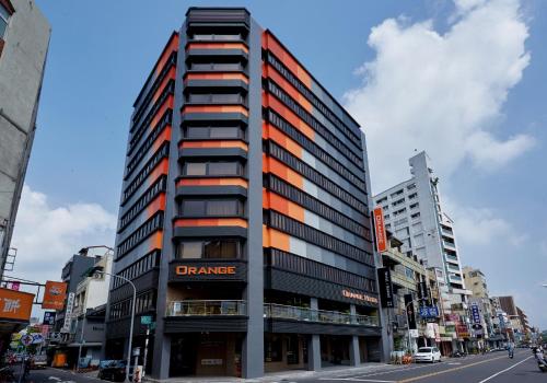 a tall building on a city street with buildings at Orange Hotel - Wenhua, Chiayi in Chiayi City