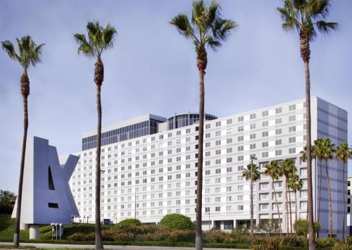 a hotel with palm trees in front of it at Hyatt Regency Los Angeles International Airport in Los Angeles