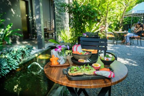 une table avec deux assiettes de nourriture dessus dans l'établissement Baba pim villa, à Chiang Mai