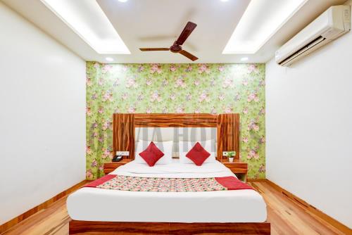 a bedroom with a bed with red pillows at Olivia Hotels - Delhi Airport in New Delhi
