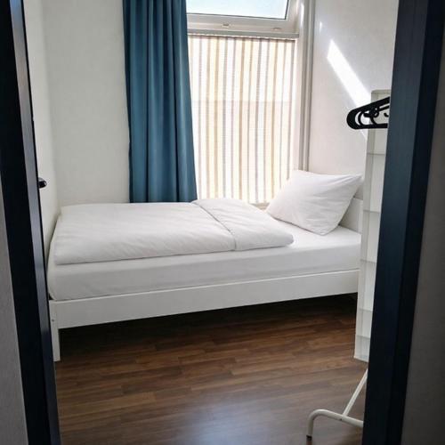 a small bed in a room with a window at Worker Place Emmerich in Emmerich