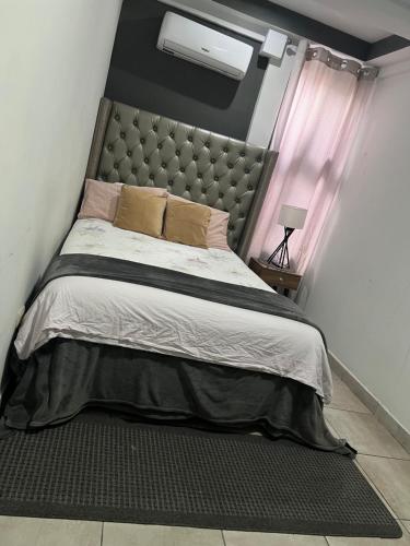 um quarto com uma cama grande com uma cabeceira grande em Pequeño y acogedor con 2 Habitaciones em Tegucigalpa