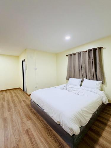 a bedroom with a large bed with white sheets at 79Hotel Rayong in Ban Hua Phrong