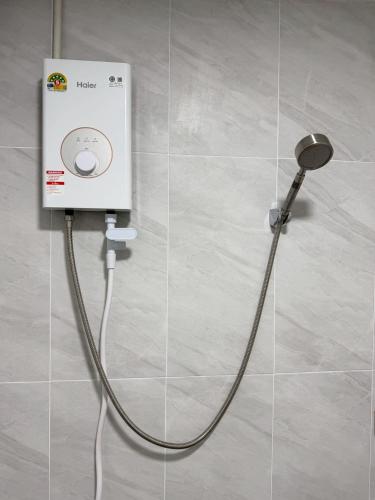 a shower with a hose attached to a wall at 79Hotel Rayong in Ban Hua Phrong