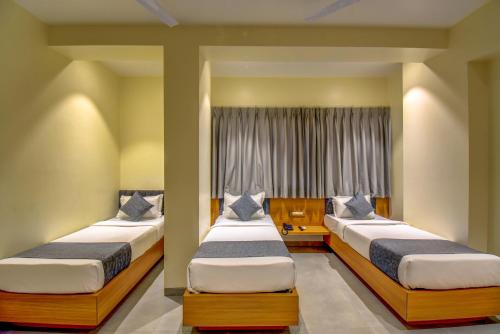 two beds in a room with a window at VITS Select Nashik in Nashik