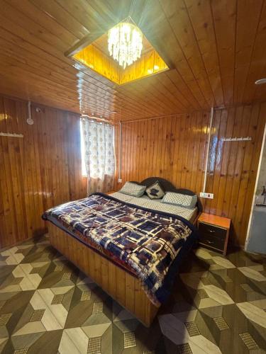 Un dormitorio con una cama en una habitación de madera. en Shyam home stay URBAN Cafe, en Nārkanda