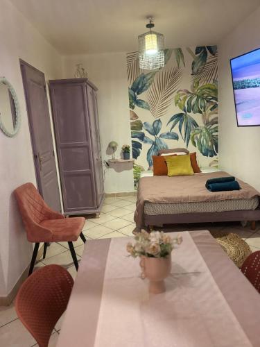 Un dormitorio con una cama y una mesa y sillas. en Centre ville, en Tarascon