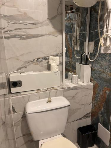 Un baño blanco con inodoro y espejo. en Centre ville, en Tarascon