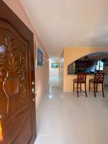 a living room with a wooden door and a kitchen at La Ureña House in La Ureña