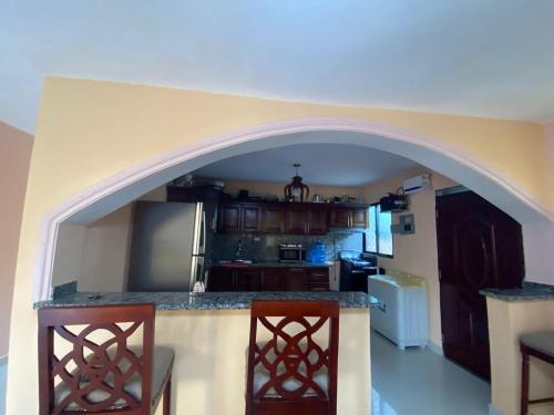 a kitchen with an arch over a counter with two chairs at La Ureña House in La Ureña