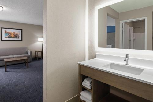 a bathroom with a sink and a mirror at Baymont by Wyndham Davenport in Davenport