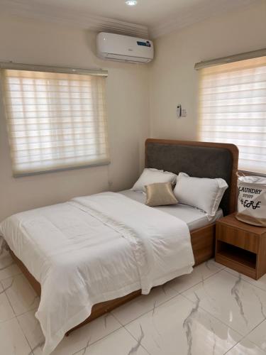 a bedroom with a large bed with white sheets and pillows at Apo Luxe 3-Bedroom Apartment in Garki
