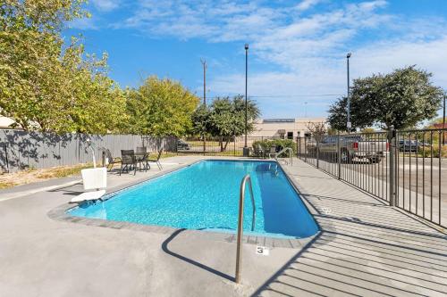 a swimming pool in a yard next to a fence at Day Inn by Wyndham San Antonio Downtown in San Antonio
