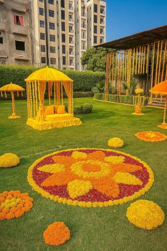 a large flower rangoli in the grass in a park at The RB's Farm in Fīrozābād