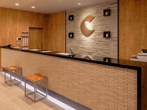 un vestíbulo con un bar con dos taburetes en Comfort Hotel Sapporo Susukino, en Sapporo