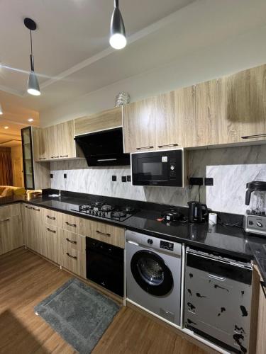 una cocina con estufa y microondas en Lisa apartment, en Kadobunkuro