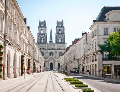 une rue vide devant un immeuble avec deux tours dans l'établissement Studio - Le Bourgogne 21, à Orléans