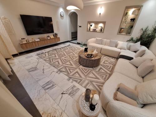 a living room with couches and a flat screen tv at East Coast Vacation Homes in Kalbā
