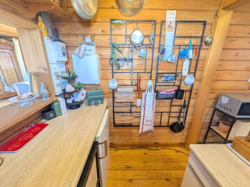 een keuken met een houten wand met keukengerei bij Holzhaus in Langatte
